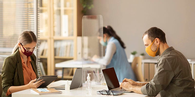Pengaruh Covid Pada Bisnis. Karyawan Bekerja Dengan Memakai Masker dan Menjaga Jarak